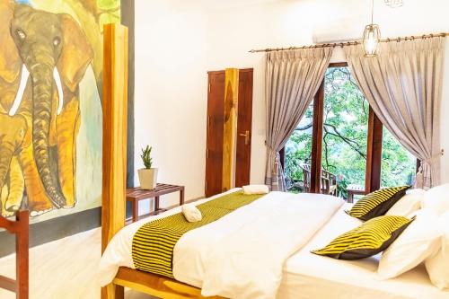 a bedroom with a bed with a painting of an elephant at Eminence ella in Ella