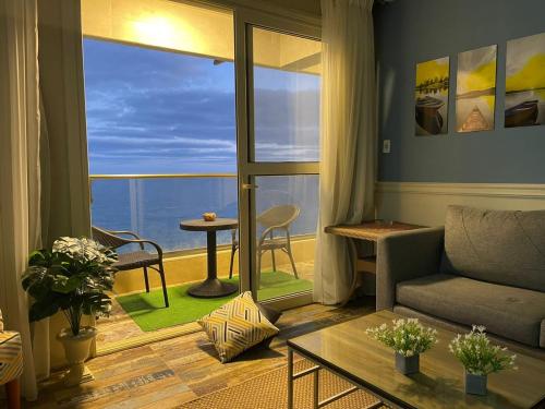 a living room with a couch and a view of the ocean at Alexander House in Alexandria