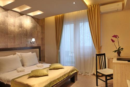 Postel nebo postele na pokoji v ubytování Garni Hotel Vozarev