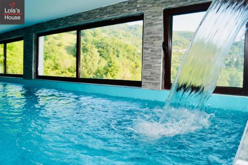 a water fountain in a swimming pool with windows at Lola's House in Jajce
