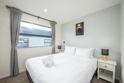 a bedroom with a large white bed and a window at Starry Lodge in Lake Tekapo