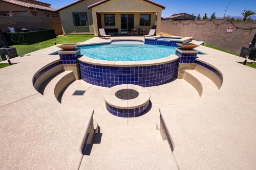 una piscina con azulejos azules alrededor en 1900 SqFt House W/25Ft Heated Pool/Spa- Strip View, en Henderson