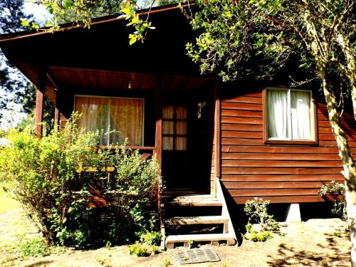 a small cabin with stairs leading to a door at Cabañas Aguas Claras in Pinto