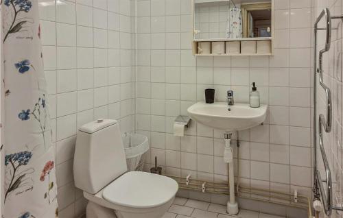 a white bathroom with a toilet and a sink at Nice Apartment In Ystad in Ystad