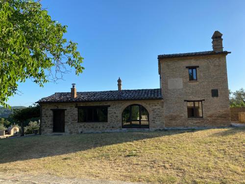 an old stone house on a hill with a tree at The Sanctuary by Caimeli in Umbertide