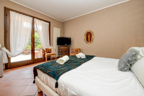 a bedroom with a bed and a large window at Prestige Suite Sirmione in Sirmione