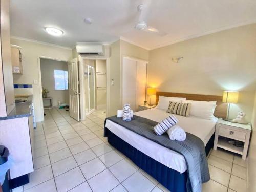 Un dormitorio con una cama grande con almohadas. en BAY VILLAS No 15, en Port Douglas