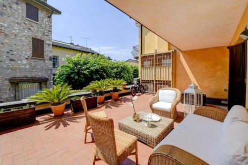 a patio with a table and chairs on a patio at Prestige Suite Sirmione in Sirmione