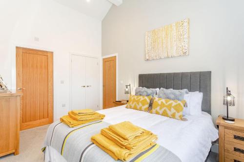 sypialnia z dużym łóżkiem z żółtymi ręcznikami w obiekcie Eames Cottage w mieście Cowling