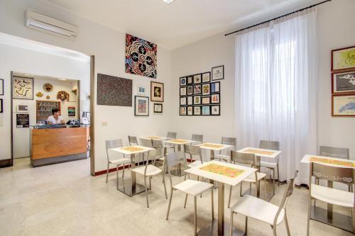 Hotel Nuova Italia في فلورنسا: غرفة طعام مع طاولات وكراسي وكاونتر
