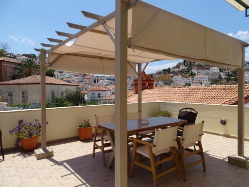 a table and chairs under an umbrella on a patio at Phaedra Hotel in Hydra