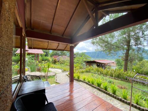 an outdoor deck with a view of a garden at Sembalun Kita Cottage in Sembalun Lawang