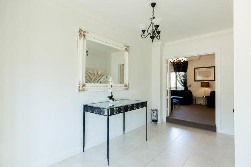 ein Wohnzimmer mit einem Tisch und einem Spiegel in der Unterkunft Chateau Yaldara House in Lyndoch