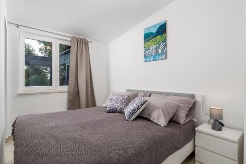 een slaapkamer met een bed met 2 kussens erop bij Villa Clara in Lovran
