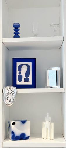 a white shelf with blue vases and a picture at WSP luxury 2b2b apartment in CBD with free parking in Melbourne