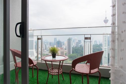 a table and chairs on a balcony with a view of the city at The Robertson by W Homestay in Kuala Lumpur