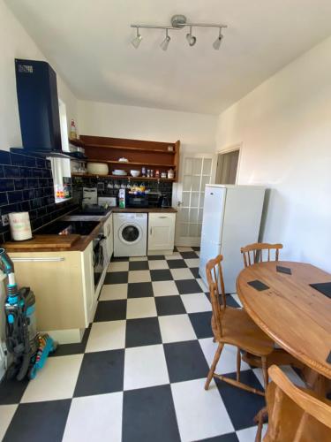 a kitchen with a black and white checkered floor at Lovely 2 Bedroom Flat Wifi Close to the beach in Bournemouth