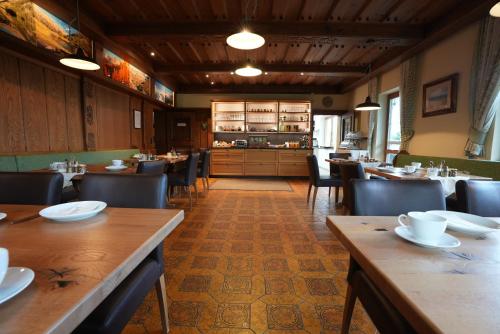 a restaurant with wooden tables and chairs and a kitchen at Pension Dachsteinhof in Ramsau am Dachstein