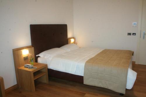 a hotel room with a bed and a night stand at Villa Eva Hotel in Ventimiglia