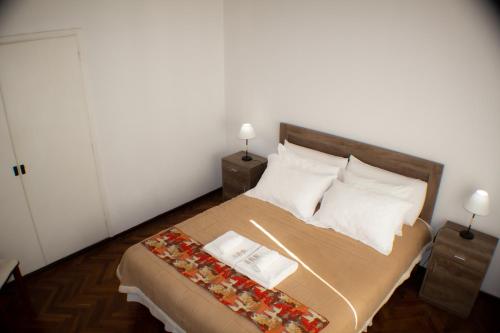 a bedroom with a bed with two tables and two lamps at Piazza Mendoza in Mendoza