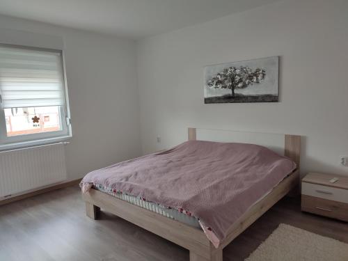una camera da letto con un letto con un albero sul muro di Kuća za odmor Balera a Šumarina