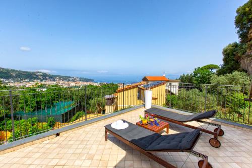 a patio with two chairs and a table on a balcony at Eterea Charming Suites in Sorrento