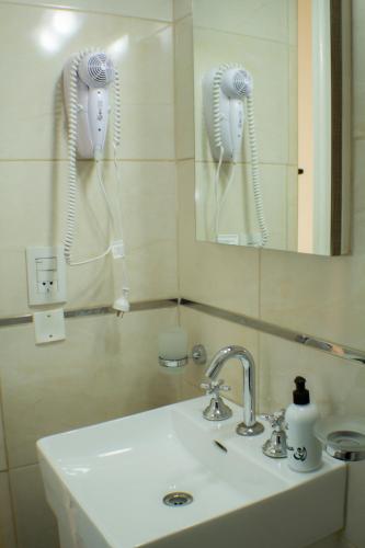 a bathroom sink with a mirror and a blow dryer at Piazza Mendoza in Mendoza