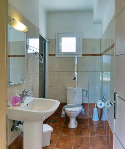 a bathroom with a sink and a toilet at YAKINTHOS GARDEN in Mytilene