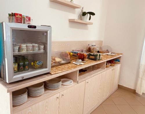 a kitchen with a counter with food and plates at Hotel La Borgata in San Pantaleo