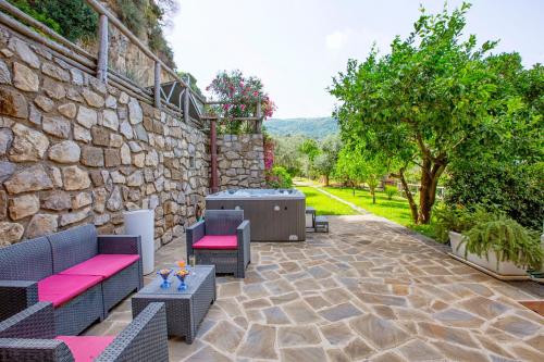 a patio with furniture and a stone wall at Eterea Charming Suites in Sorrento