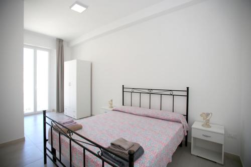 um quarto com uma cama preta e uma colcha rosa em Appartamenti Luce Vieste em Vieste