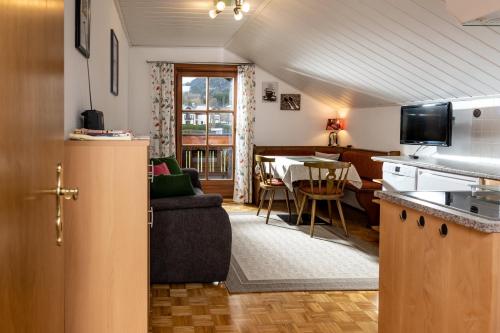 eine Küche und ein Wohnzimmer mit einem Sofa und einem Tisch in der Unterkunft Kerschbaumergut in Grossgmain