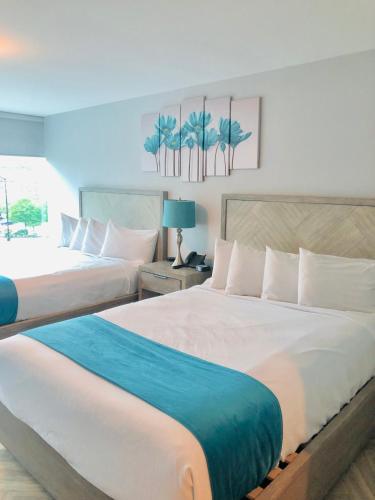 a hotel room with two beds and a blue blanket at Athens Central Hotel in Athens