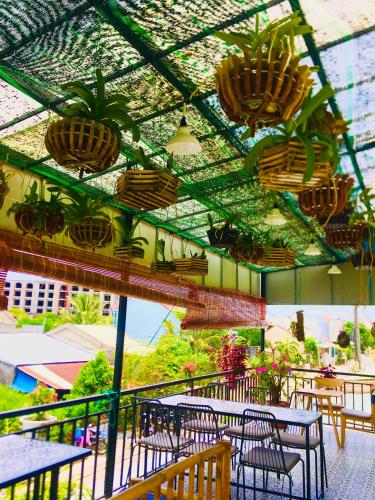 a patio with tables and chairs and potted plants at An Bang Sea Adventure Homestay Hoi An in Hoi An