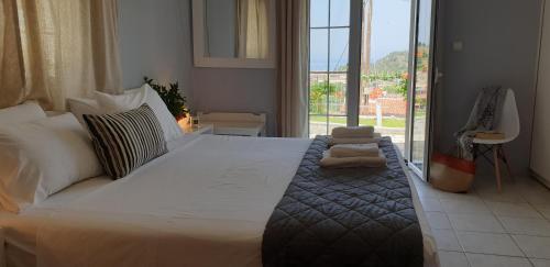 a bedroom with a large bed with a large window at Sivotahomes-blu in Syvota