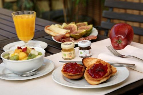 a table with plates of food and a bowl of fruit at Hotel De Prati in Ferrara
