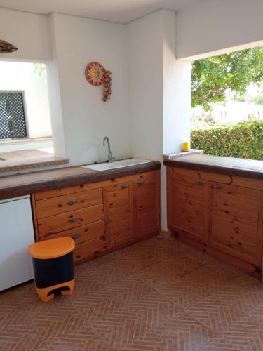 a kitchen with wooden cabinets and a sink and a window at La Torre Golf Resort, Mero, Torre-Pacheco, Murcia in Murcia