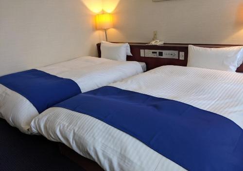 two beds sitting next to each other in a hotel room at Ichinomiya City Hotel in Ichinomiya