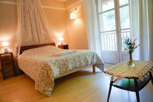 ein Schlafzimmer mit einem Bett und einem großen Fenster in der Unterkunft La Boutique Fotoon in Blesle