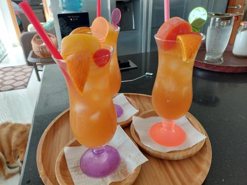 two glasses of orange juice and oranges on a tray at La Vida Selfcatering Apartements in Mahe