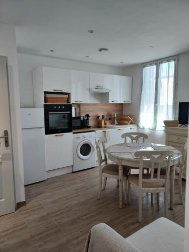 une cuisine et une salle à manger avec une table et des chaises dans l'établissement Toulon, soleil et douceur I, à Toulon
