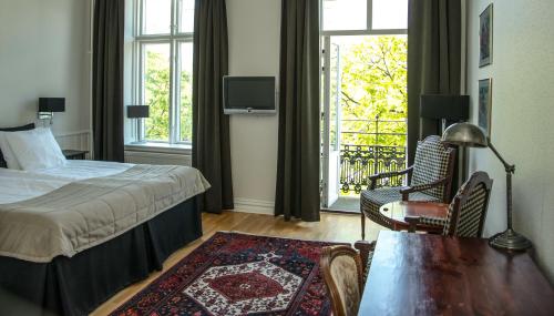 a hotel room with a bed and a table and chairs at Hotell Linnéa - Helsingborg in Helsingborg