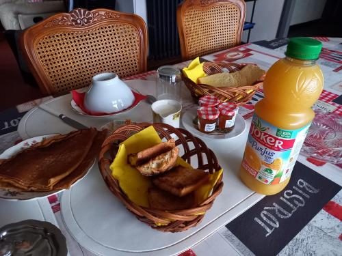 stół z koszem z jedzeniem i butelką soku pomarańczowego w obiekcie TALL AR MOR w mieście Pleumeur-Bodou