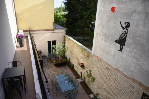 a mural of a woman holding a balloon on a wall at BB LETTERARIO in Ravenna