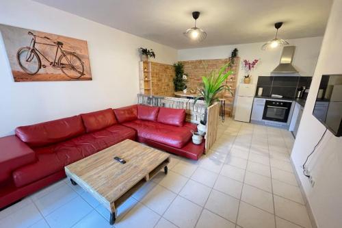 un salon avec un canapé rouge et une table basse dans l'établissement La Cave Proche gare Centre-Ville  Wifi-Netflix, à Marseille