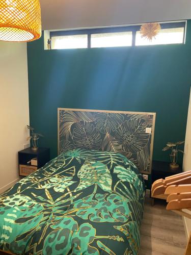 1 dormitorio con cama y pared azul en Appartement en rez de jardin tout équipé en Fleurance