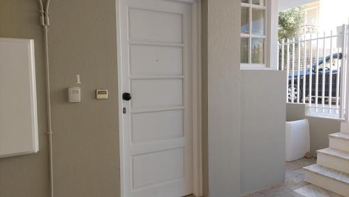 a white door in a room with a window at Aphrodite goddess in Artemida