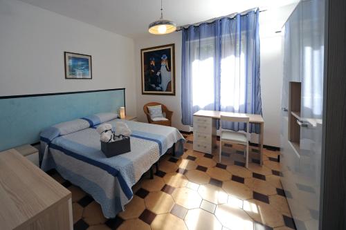 ein Schlafzimmer mit einem Bett und einem Tisch mit einem Teddybär darauf in der Unterkunft Appartamento Parco Tarragona in Alghero