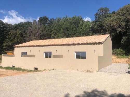 a large white building with trees in the background at Casa di lise e bastien in San-Nicolao