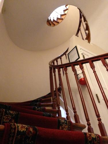 a staircase with a light on the ceiling next to a stair case at Pring Guesthouse in Hamilton